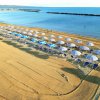 Spiaggia con ombrelloni blu e bianchi.
