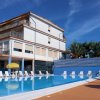 Piscina con sedie a sdraio e edificio sullo sfondo.