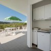 Terrazza con ombrelloni verdi e vista collinare.