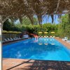 Piscina con lettini e ombrelloni gialli.