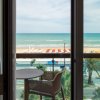 Vista sul mare dalla finestra con tavolino e sedia sul balcone.