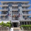Facciata di un hotel con balconi e bandiere.