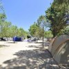 Area campeggio con tende tra alberi.