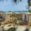 Bungalow in legno vicino al mare, con tende bianche.
