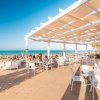 Terrazza di un bar fronte mare con sedie e tavoli.
