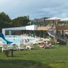 Piscina all'aperto con scivolo e sdraio.