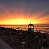 Spiaggia al tramonto con ombrelloni chiusi e mare calmo.