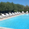 Piscina all'aperto con lettini bianchi.