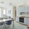 Cucina moderna con tavolo in legno e sedie blu.