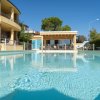 Piscina blu con edificio giallo sullo sfondo.