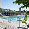 Piscina con lettini e ombrelloni grigi.
