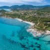 Costa con mare turchese e colline verdi.