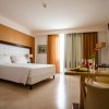 Camera d'albergo con letto matrimoniale e tavolino apparecchiato.