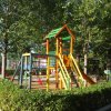 Area giochi con struttura colorata e alberi.