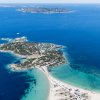 Isola verde con spiaggia sabbiosa e mare blu.