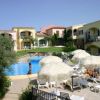 Complesso residenziale con piscina e lettini bianchi.