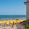 Spiaggia con ombrelloni gialli e mare calmo.