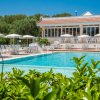 Piscina all'aperto con lettini e ombrelloni bianchi.