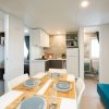 Sala da pranzo e cucina in un interno moderno, con tavolo apparecchiato e divano blu.