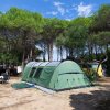 Grande tenda verde in un campeggio con alberi.