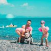 Persona con due bambini e un cane sulla spiaggia.