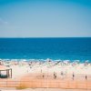 Spiaggia con ombrelloni e mare azzurro.