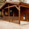 Casetta di legno con veranda e recinzione con cancello.